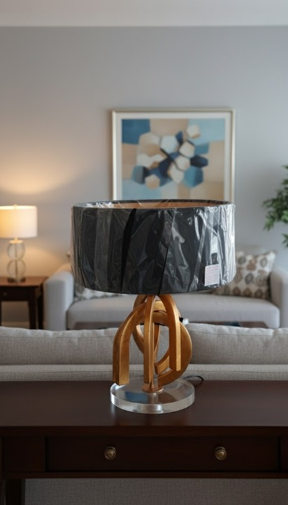 Arlumina Golden Abstract Knot lamp, etched gold pillar base with white pleated shade and decorative silk tassel.